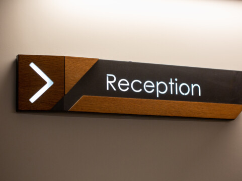 The,Reception,Sign,With,Direction,Arrow,On,The,Wall